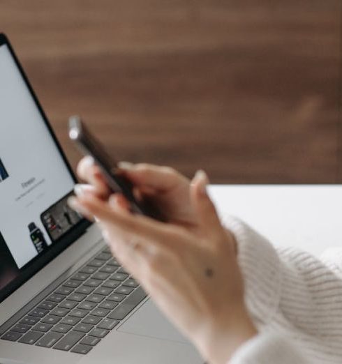 Product Page - Asian woman shopping online with a laptop and smartphone at home.