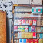 Product Descriptions - Vintage display of cigarette packs on an old wooden shelf, evoking a sense of nostalgia.