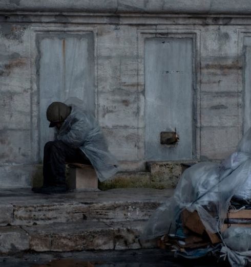 Cart Abandonment - Homeless Man with Cart in Rain near Old Building