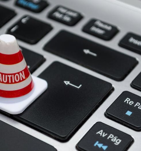 Data Security - Miniature caution cone on a computer keyboard symbolizing data security and control.