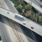 Organic Traffic - High-angle aerial shot of a highway intersection with various vehicles in motion.