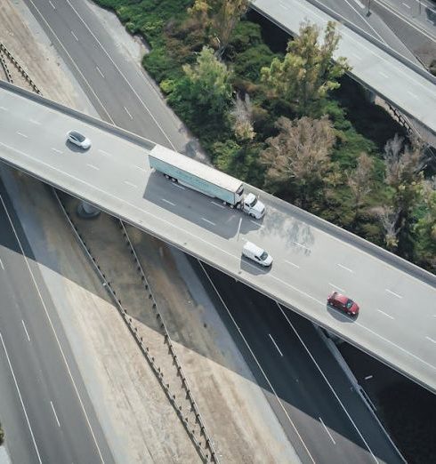 Organic Traffic - High-angle aerial shot of a highway intersection with various vehicles in motion.