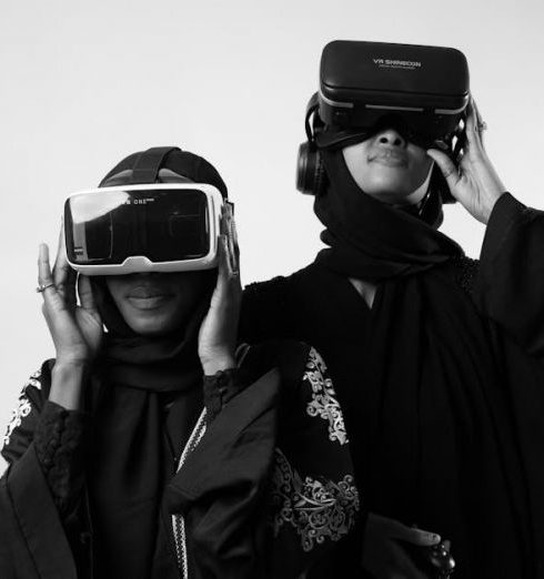 Gamification - Two women in traditional attire enjoying virtual reality, showcasing modern technology.