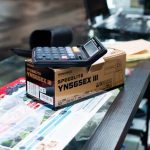 Flash Sales - Close-up of a payment terminal and camera flash box on a store counter.