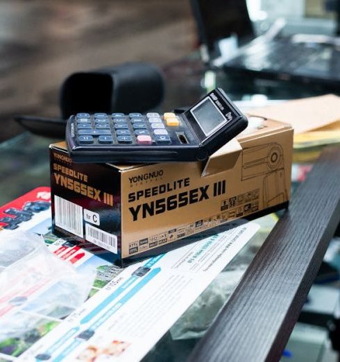 Flash Sales - Close-up of a payment terminal and camera flash box on a store counter.