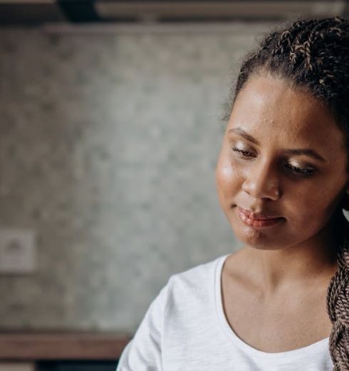 Customer Journey - Woman with dreadlocks shopping online using a laptop in her kitchen.