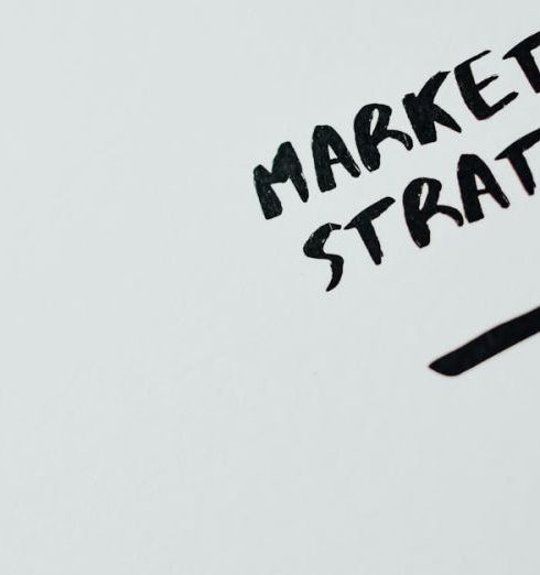 Sales Goals - Close-up of handwritten 'Marketing Strategy' text with an arrow on white background.