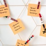 Email Marketing - Sticky notes with holiday marketing ideas clipped to a wall grid.