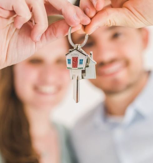 Closing - Young couple holding keys to their new home, symbolizing a fresh start and investment in real estate.