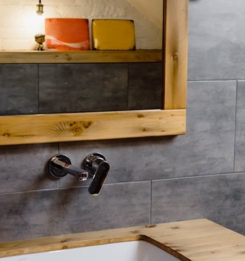 Bathroom Trends - Brown Wooden Framed Mirror Hanging on the Gray Wall