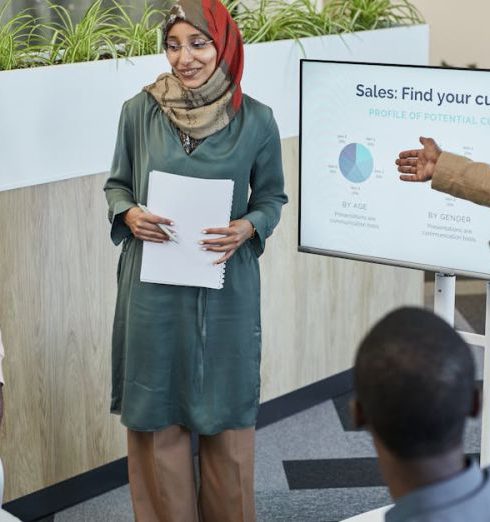 Sales Team - Team of professionals discussing sales strategy during a business presentation in a modern office.