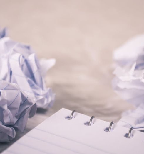 Rejection - Crumpled papers scattered around a notepad, symbolizing creative process and ideas.