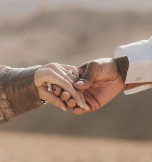 Bonds - Romantic couple holding hands in the Agafay Desert, capturing love and connection on a sunny day.