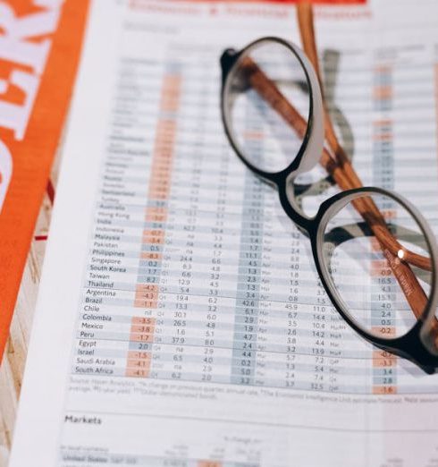 Mutual Funds - Close-up of financial documents with eyeglasses, depicting data analysis and business insights.