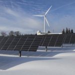 Renewable Energy - Solar panels and wind turbine in a snowy landscape, showcasing renewable energy sources.