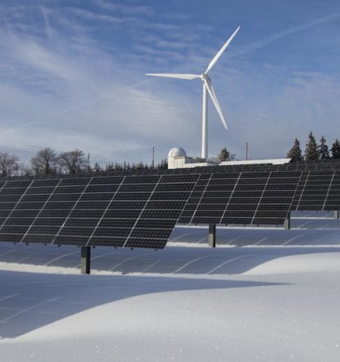 Renewable Energy - Solar panels and wind turbine in a snowy landscape, showcasing renewable energy sources.