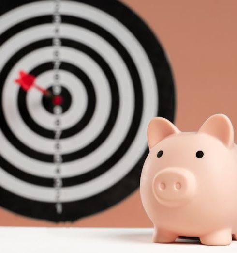 Investment Goals - A piggy bank in front of a dartboard symbolizing financial goals and smart savings.