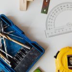 Small Businesses - A selection of carpentry tools including drill bits, measuring tape, and protractor in an overhead shot.