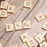 ESG Investing - Wooden letter tiles spell ESG on a rustic wooden surface, emphasizing sustainability.