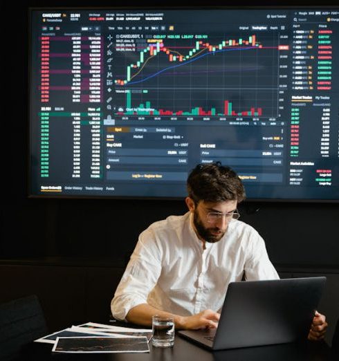 Financial Advisor - Businessman using laptop in office analyzing stock market charts. Professional finance and investment concept.