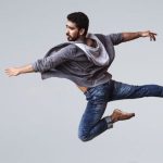 Performance - A male contemporary dancer in casual wear leaping gracefully in mid-air, showcasing agility and flexibility.