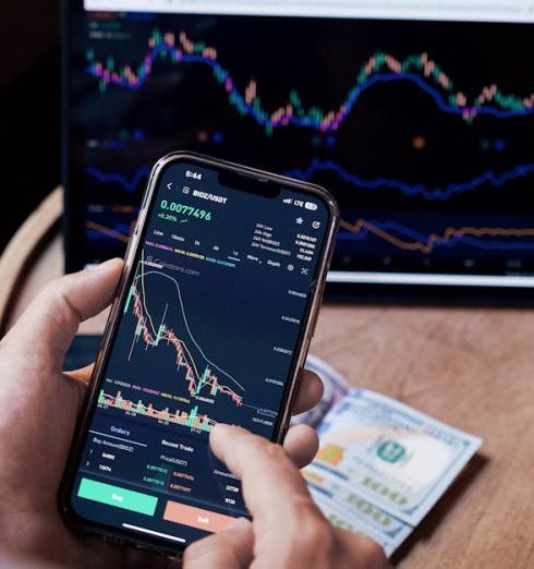 Market Trends - Close-up of a person trading stocks using a smartphone and a tablet.