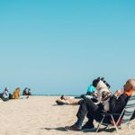 Retirement - Elderly man with dog enjoying a sunny day at the beach in Barcelona, Spain.