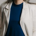 Employee Retention - Elegant businesswoman smiling in a studio portrait with a stylish and formal look.