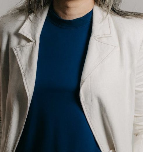 Employee Retention - Elegant businesswoman smiling in a studio portrait with a stylish and formal look.