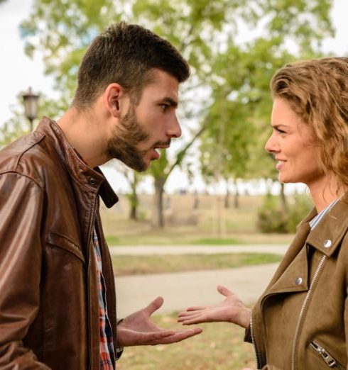 Conflict - A couple having an argument outdoors, expressing frustration and conflict.