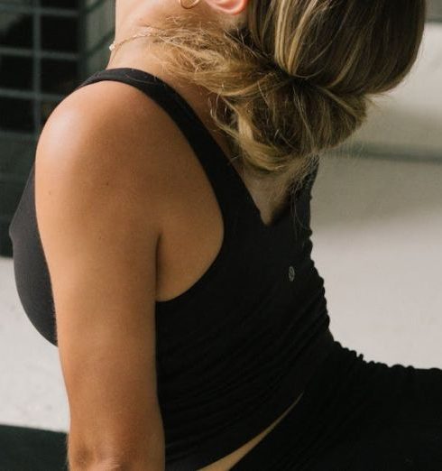 Health Benefits - Young woman stretching in an upward-facing dog yoga pose indoors on a mat.