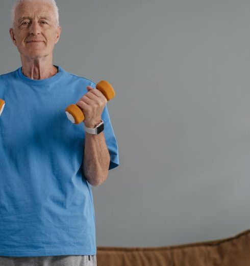 Wellness Programs - Elderly man lifting dumbbells indoors, promoting a healthy lifestyle.