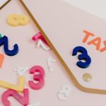 Payroll Taxes - Bright plastic numbers scattered over a tax envelope, symbolizing accounting and finance concepts.