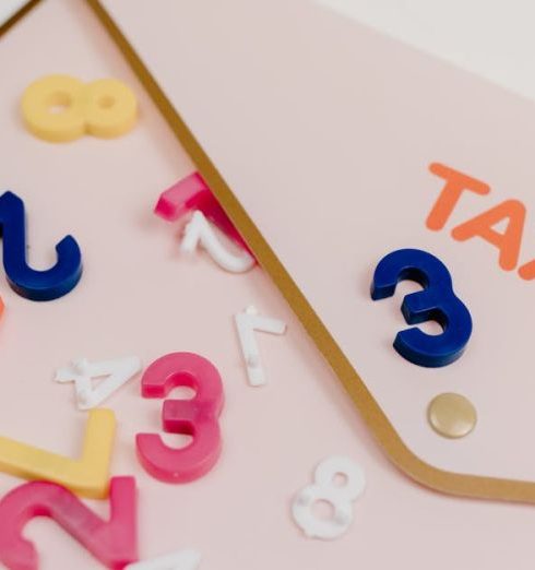 Payroll Taxes - Bright plastic numbers scattered over a tax envelope, symbolizing accounting and finance concepts.