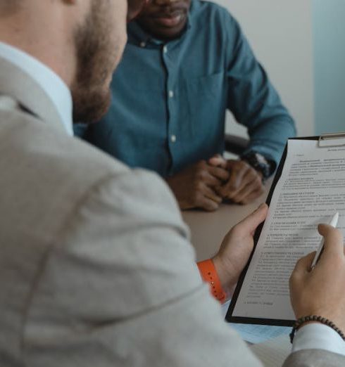 Feedback - A recruiter reviews a candidate's documents during a job interview in a modern office setting.