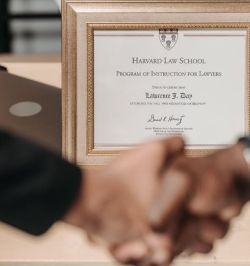 Recognition Programs - Harvard Law School degree with handshake representing achievement and professional agreement.