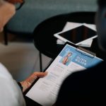 Talent Acquisition - Business professionals conducting an interview with resume on clipboard in an office setting.