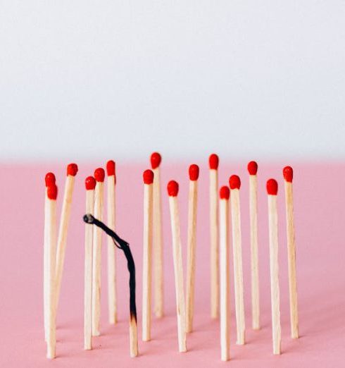 Burnout - Artistic representation of burnout with matchsticks on a pink surface in a studio setting.