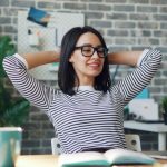 Job Satisfaction - Young Woman Using a Laptop in a Modern Office