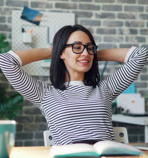 Job Satisfaction - Young Woman Using a Laptop in a Modern Office