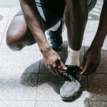 Cross-Training - Close-up of an athlete tying sneakers, ready for training in an urban environment.