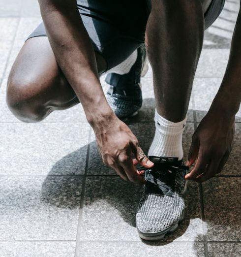 Cross-Training - Close-up of an athlete tying sneakers, ready for training in an urban environment.