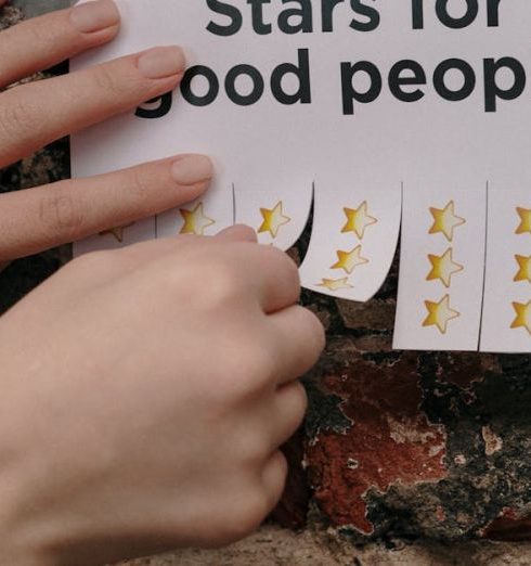 Reward System - Hands Sticking Paper Sheet on Wall