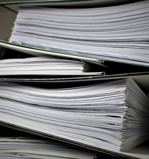 Policies - Close-up of stacked binders filled with documents for office or educational use.