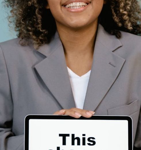 Vision Statement - Young woman smiling while holding a sign that reads 'This change everything'.