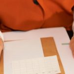 Action Plan - Businesswoman holding a clipboard with notes, planning and organizing tasks.