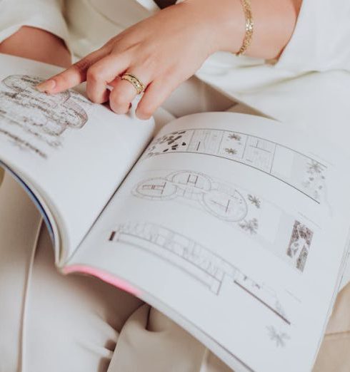 Gap Analysis - Close-up of an Elegant Woman Sitting on a Sofa Pointing at an Illustration in a Book