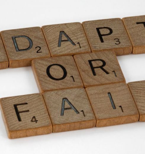 Change Management - Scrabble tiles spell 'Adapt or Fail' on a white background, conveying a motivational message.