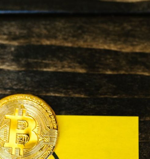 Financial Risk - Bitcoin coin with a downward trend graph on a yellow sticky note, symbolizing market decline.