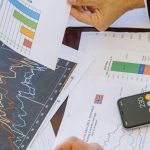 Insurance - Business professionals analyzing financial charts and graphs during a meeting.